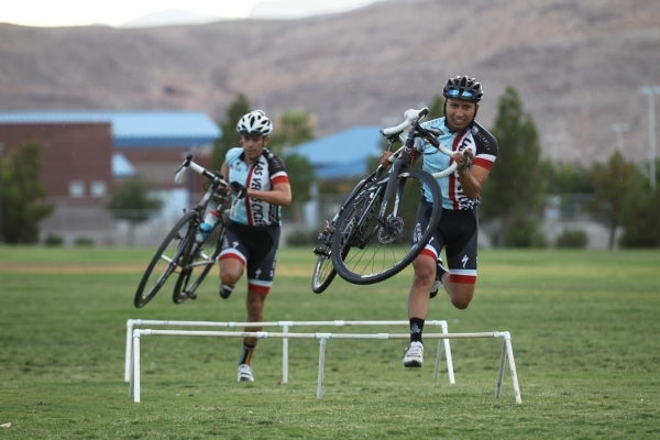 Las Vegas Cyclo-Cross member Mark Smith, right, jumps over an obstacle while warming up at Red Ridge Park, near Durango Road and Arby Avenue. The group plans to compete in the UCI World Cup event  ...
