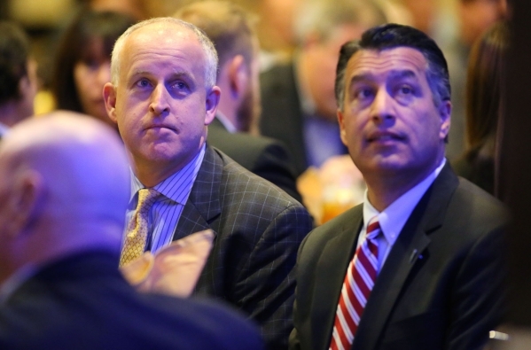 Tesla executive Diarmuid O‘Connell, left, and Gov. Brian Sandoval listen to a speaker at the Governor‘s Business Conference at the Atlantis Resort Casino in Reno on Tuesday, Aug. 25, 2 ...