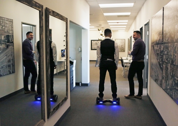 Kamran Zand, owner and broker at Luxury Estates International, center, moves through the office on a Hoverboard at Luxury Estates International Thursday, Feb. 4, 2016, in Las Vegas. The real estat ...