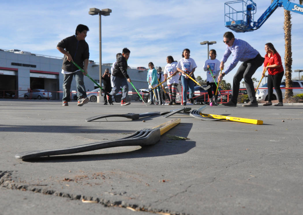 Murray Craven, right and forward, senior vice president of the Vegas Golden Knights and former National Hockey League center, plays street hockey with children from After-School All-Stars Mar. 7 a ...