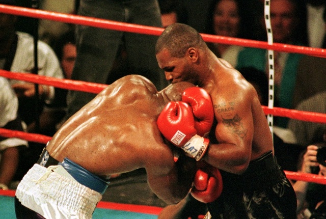 Mike Tyson bites the ear of Evander Holyfield during the third round of the WBA Heavyweight Championship fight in Las Vegas, June 28. The fight was called after Tyson was disqualified. (File photo)