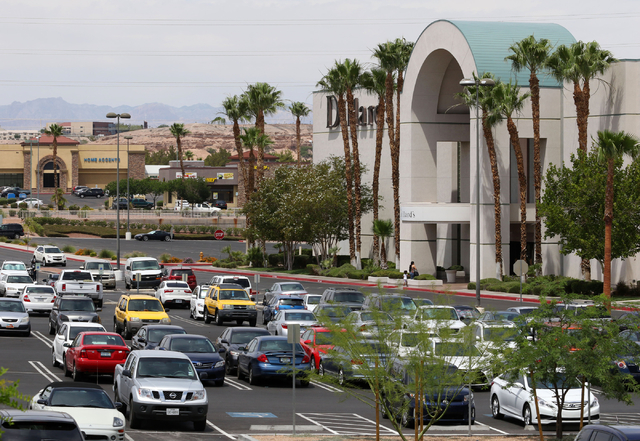 People walk near a building wrap announcing new businesses to come at  Galleria at Sunset mall Thursday, June 4, 2015, in Henderson. Galleria at  Sunset, which has expanded to just over 1