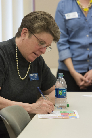 Lori Murphy, chapter chair of SCORE fills out a Girl Scout Cookies order form during a presentation about the business of Girl Scout Cookies and the Girl Scouts CEO in Training program at the Urba ...