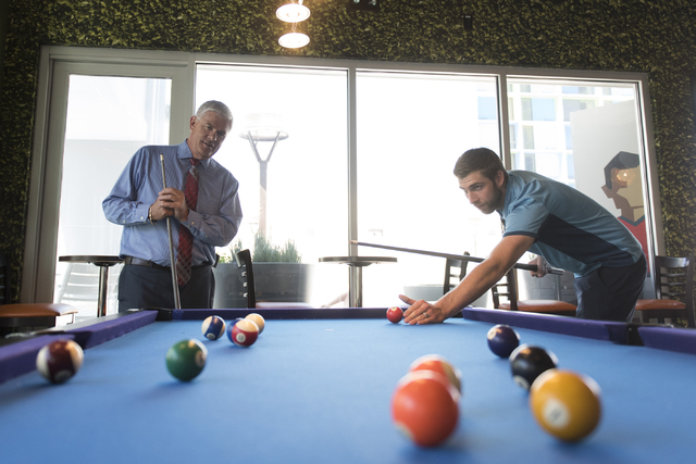 Mark Kelly, vice president of casino operations with Bally's, Paris and Planet Hollywood, left, and his son, Ryan Kelly, pool operations manager at The Linq Hotel, play a game of pool in the recre ...