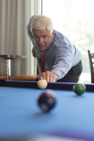 Mark Kelly, vice president of casino operations with Bally's, Paris and Planet Hollywood, plays a game of pool with his son, Ryan Kelly, pool operations manager at The Linq Hotel, out of picture,  ...