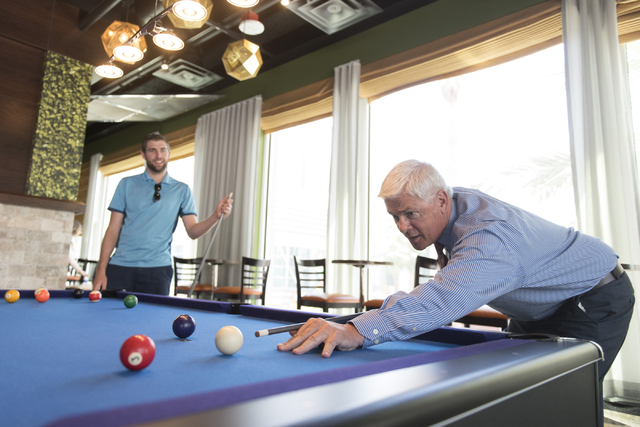Mark Kelly, vice president of casino operations with Bally's, Paris and Planet Hollywood, right, and his son, Ryan Kelly, pool operations manager at The Linq Hotel, play a game of pool in the recr ...