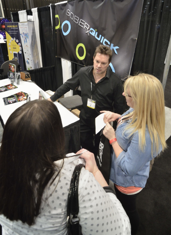 Jared Anderson, president of Liquid Innovations, center, talks with Ashley Burrel, assistant manager of the 2nd Street Slammer bar in Hastings, Neb., and Abby Monroe, who manages the bar, at Ander ...