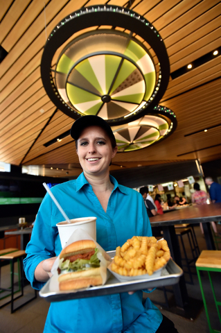 Restaurant manager Michelle Stripp displays a Chick'n Shack sandwich with crinkle-cut french fries and a chocolate shake at the Shake Shack location at the New York-New York hotel-casino Monday, M ...