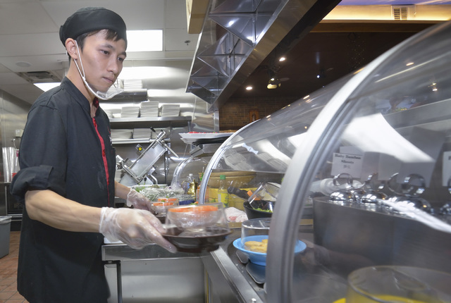 Sashimi chef K.C. Leung loads dishes onto the refrigerated conveyor belt used to take food directly to customers at the Chubby Cattle restaurant at 3400 S. Jones Blvd. in Las Vegas on Thursday, Se ...