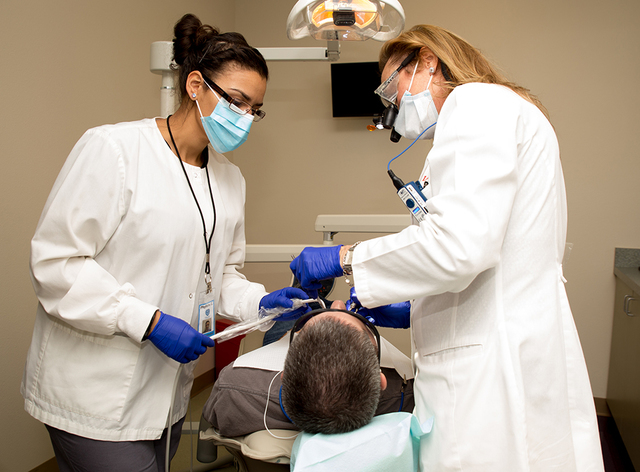 Dental Director Dr. Lydia Wyatt, right, works with an assistant on a patient. The dental clinic features four separate exam rooms furnished with state-of-the-art equipment and supplies. (Tonya Har ...