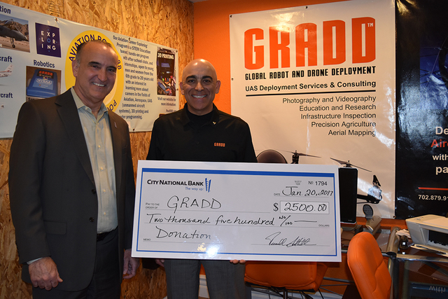 Scott Aney (left), Nevada regional executive for City National Bank, presents Reza Karamooz, CEO of GRADD, with a $2,500 donation to fund ongoing research and education programs related to the dro ...