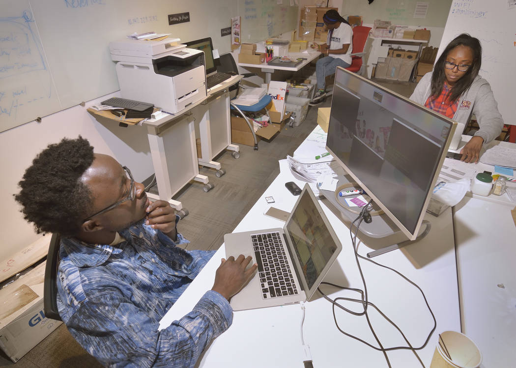Chief technology officer Kwame Ampem, left, production manager LaTasha Darden, background, and CEO Tamar Lucien from a company called Mental Happy work at the RedFlint Experience Center at 300 S.  ...