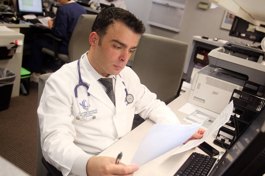 Fadi Braiteh, MD of Comprehensive Cancer Centers of Nevada, looks over paperwork.