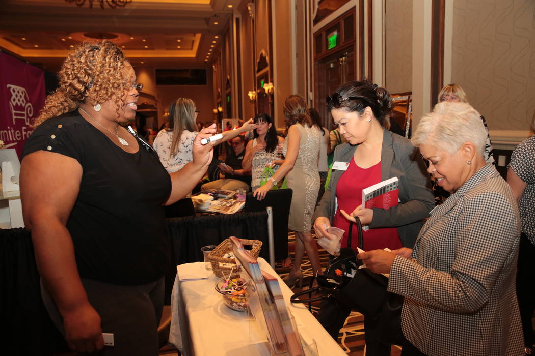 From left, Celyse Nsubuga, community health worker with Dignity Health, speaks to Pearl Irwin, business specialist with Wells Fargo, and Verena Culpepper, also with Wells Fargo, during the Henders ...