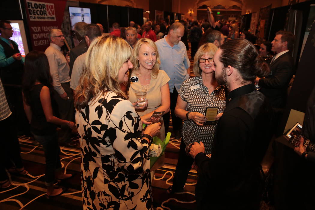 From left, Christina Weick of Bank of Nevada, Tamra Coulter of Signature Real Estate Group and Lisa Molchon from Mutual of Omaha Bank speak to Ryan Doyle, game master at Escapology during the Hend ...