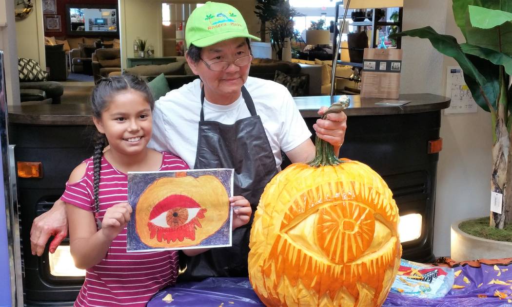 At a Chanh Boupha pumpkin carving event held in the Atrium at Walker Furniture on Oct. 28, chef Boupha carved first-place winner, fourth-grader Briana Magdaleno’s drawing. (Courtesy)