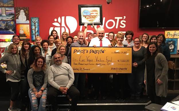 Pinot’s Palette owners, Reed and Judy Alewel, left, front row, and their staff, present Clark County Commissioner Steve Sisolak a $11,821 check for the Las Vegas Victims’ Fund on Nov. 7. (Cour ...