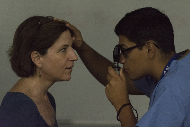 Student Jose A. Leon, right, examines Lisa Rosenberg, assistant professor of geriatrics with Roseman University of Health Sciences, with an ophthalmoscope, viewing her retina and blood vessels. (J ...