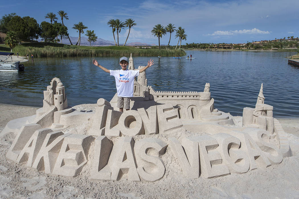 A boy stands by a sand art creation he helped build. (Lake Las Vegas)
