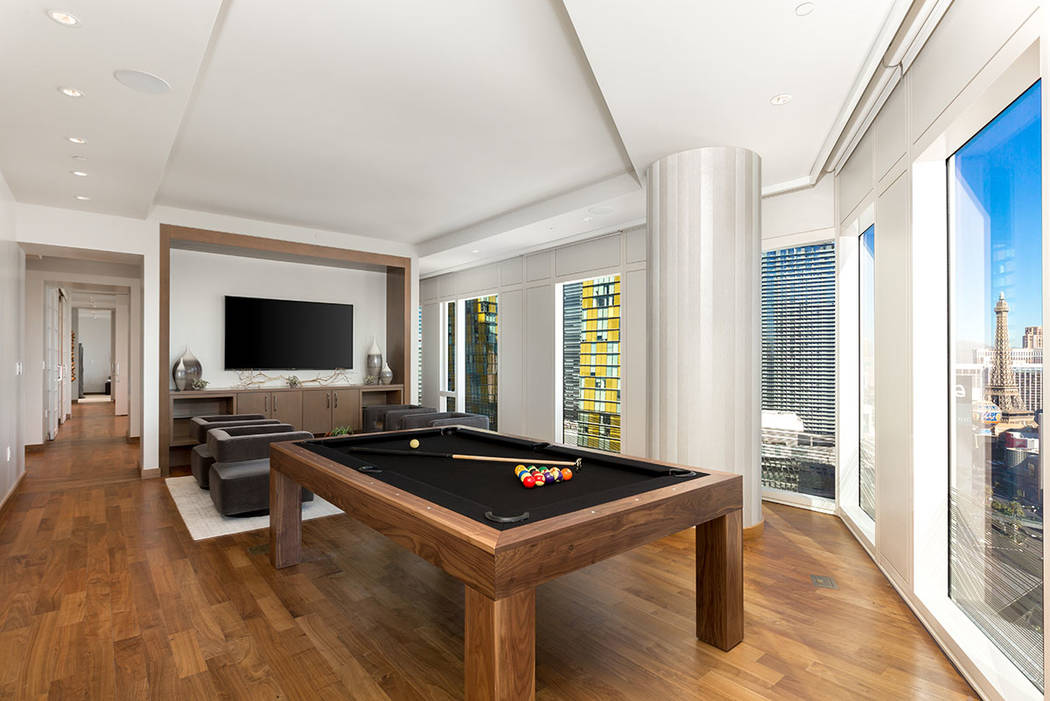 The living room in Waldorf Astoria unit No. 2403 has a game area. (Luxury Estates International)