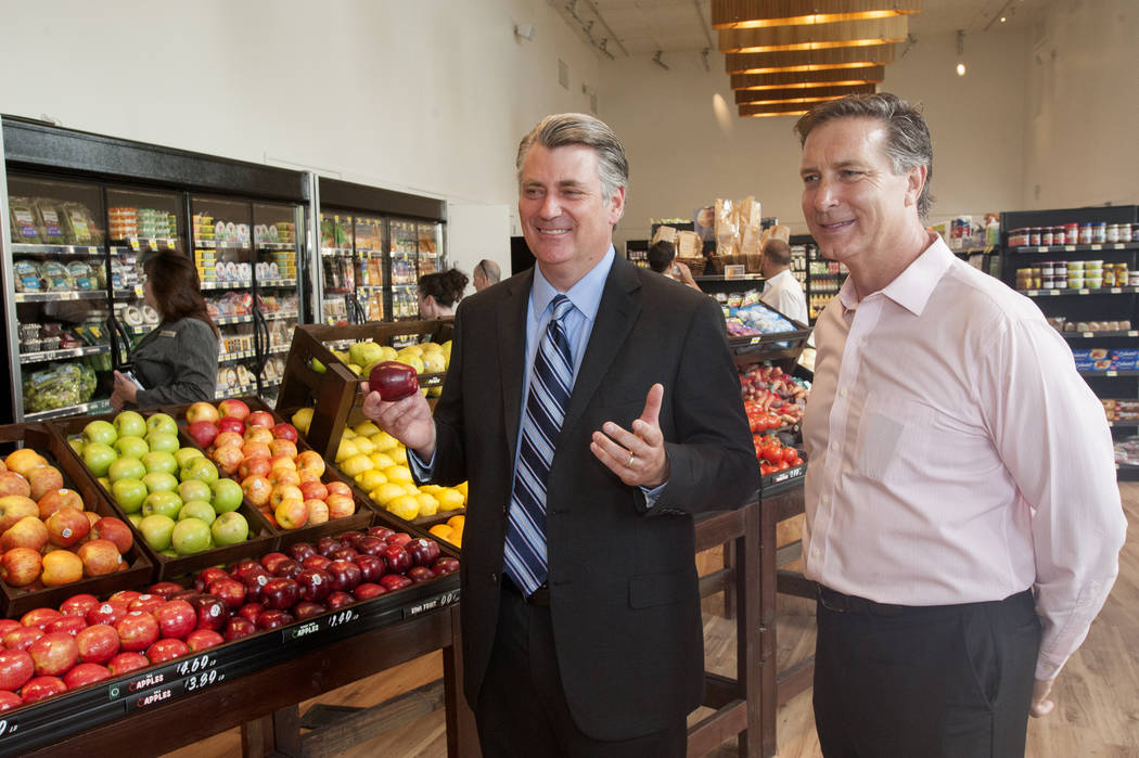 Patrick Parker, Raintree Investment Corp. president, left, and Doug McPhail, Seasons grocery store general manager talk on opening day for the market, June 21, 2016, in MonteLago Village at Lake L ...