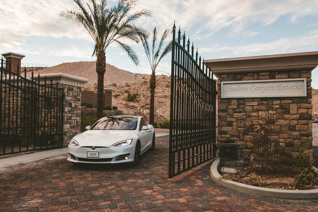 A private gate at the front of the property allows access up a sloping driveway to a six-car ga ...