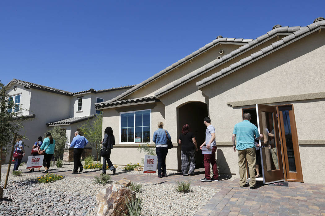 Attendees tour model houses by Beazer Homes at Falcon Ridge community in North Las Vegas during ...