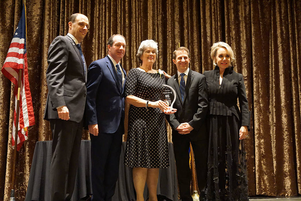 Kathleen Miller, center, accepts the award for Outstanding Nonprofit for Living Grace Homes. Fr ...