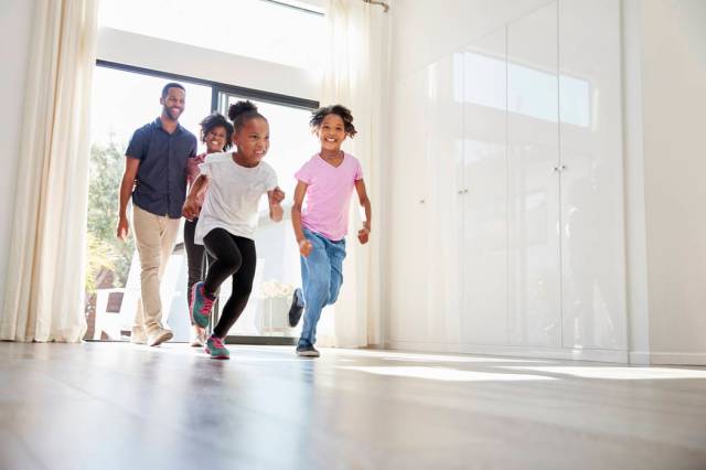 Excited Family Exploring New Home On Moving Day