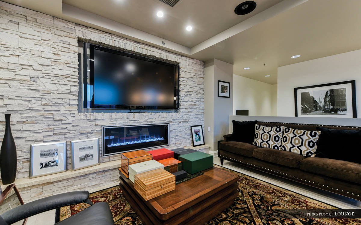The third level is designed as a lounge area with a stacked stone linear fireplace, wet bar, ba ...