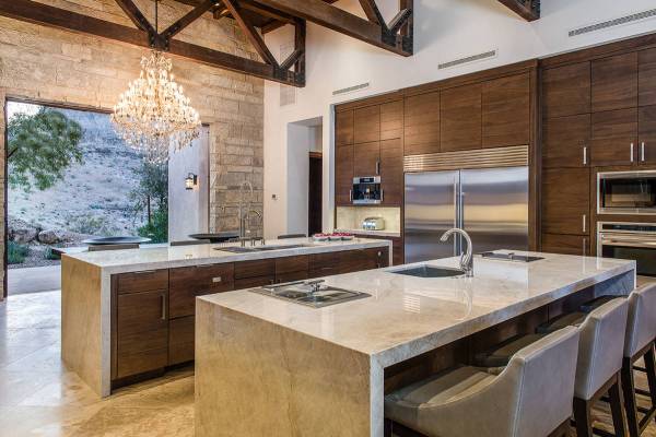 The large kitchen has double islands with seating, upgraded appliances, a modern design and a d ...