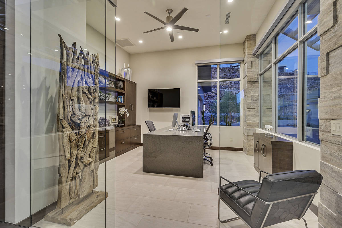 The home has two custom offices. This one has a glass door that helps create a comfortable work ...