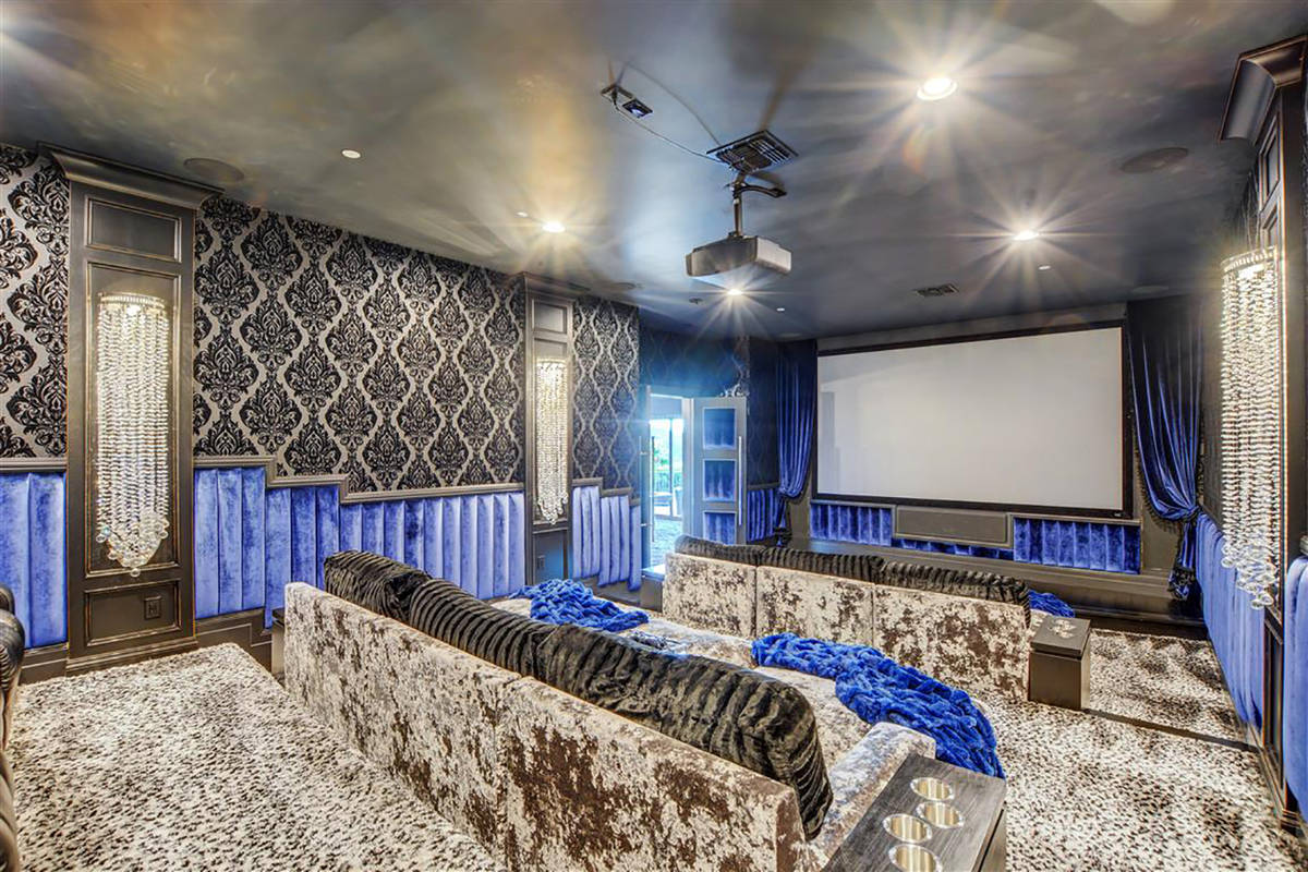 A home theater has 12 seats and lounging couches while a game room next to it with vintage pinb ...