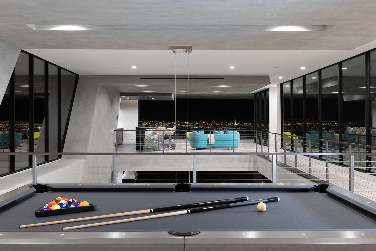 A linear catwalk connects the game room to the bar area, providing views of the main level. (Sy ...