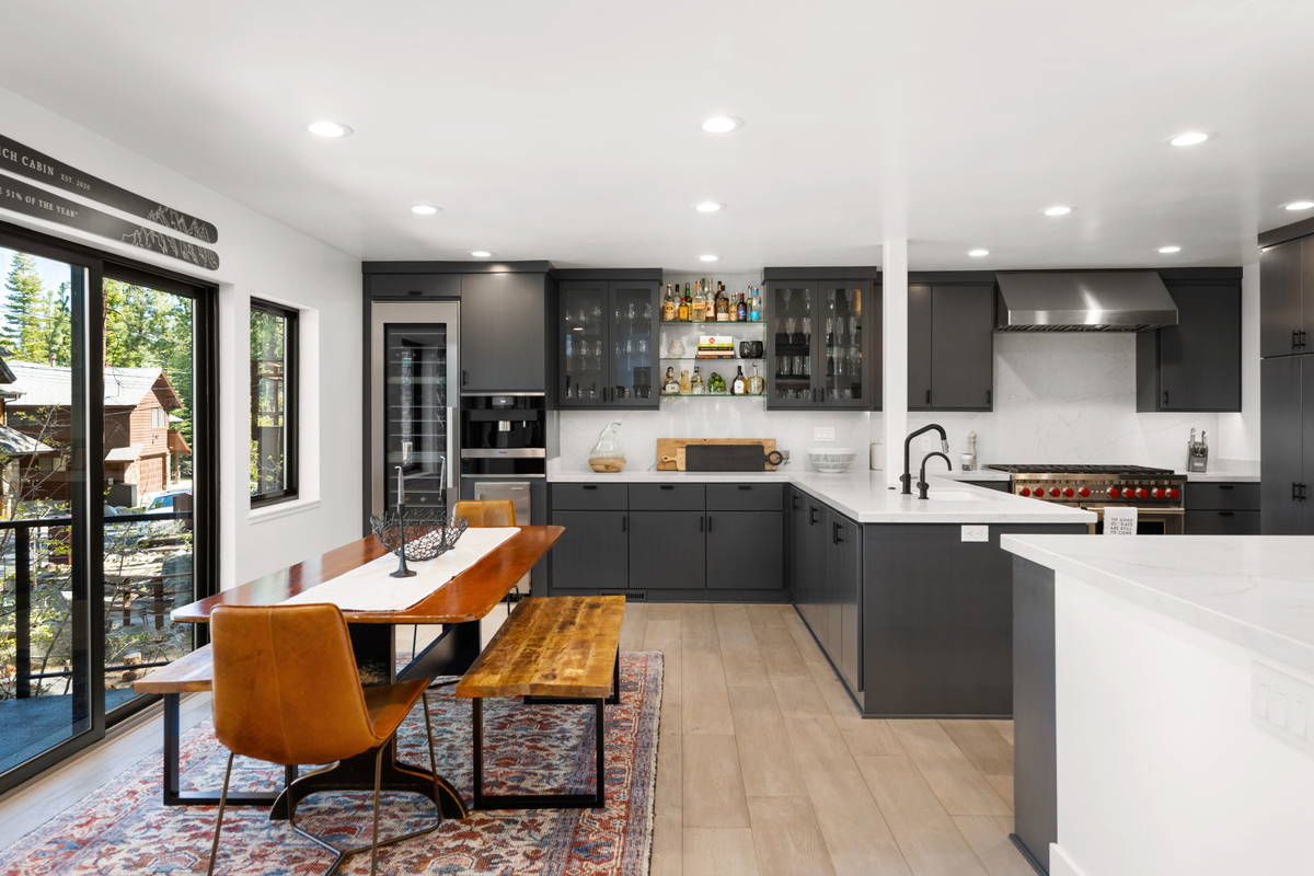 Striking white quartz counters contrast the dark gray custom cabinetry in the chic kitchen. A l ...