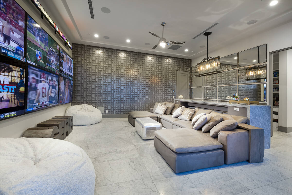 Off the kitchen is the home’s sportsbook theater. Six 80-inch televisions line the outer wall ...