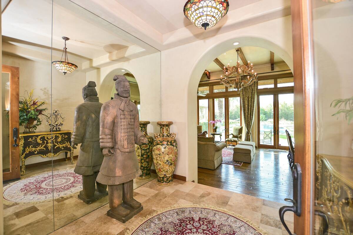 The foyer of the main house opens to a formal living and dining area and great room, showcasing ...