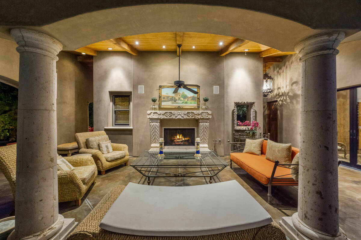 An outdoor living room showcases a custom stone fireplace and dining area. (BHHS)