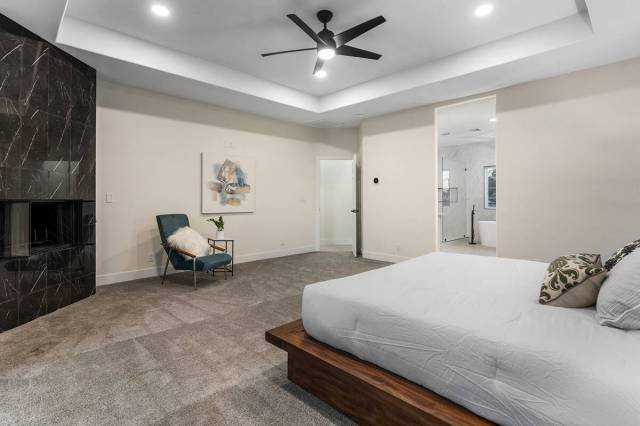 Master bedroom has a black fireplace. (Sotheby’s International Realty)