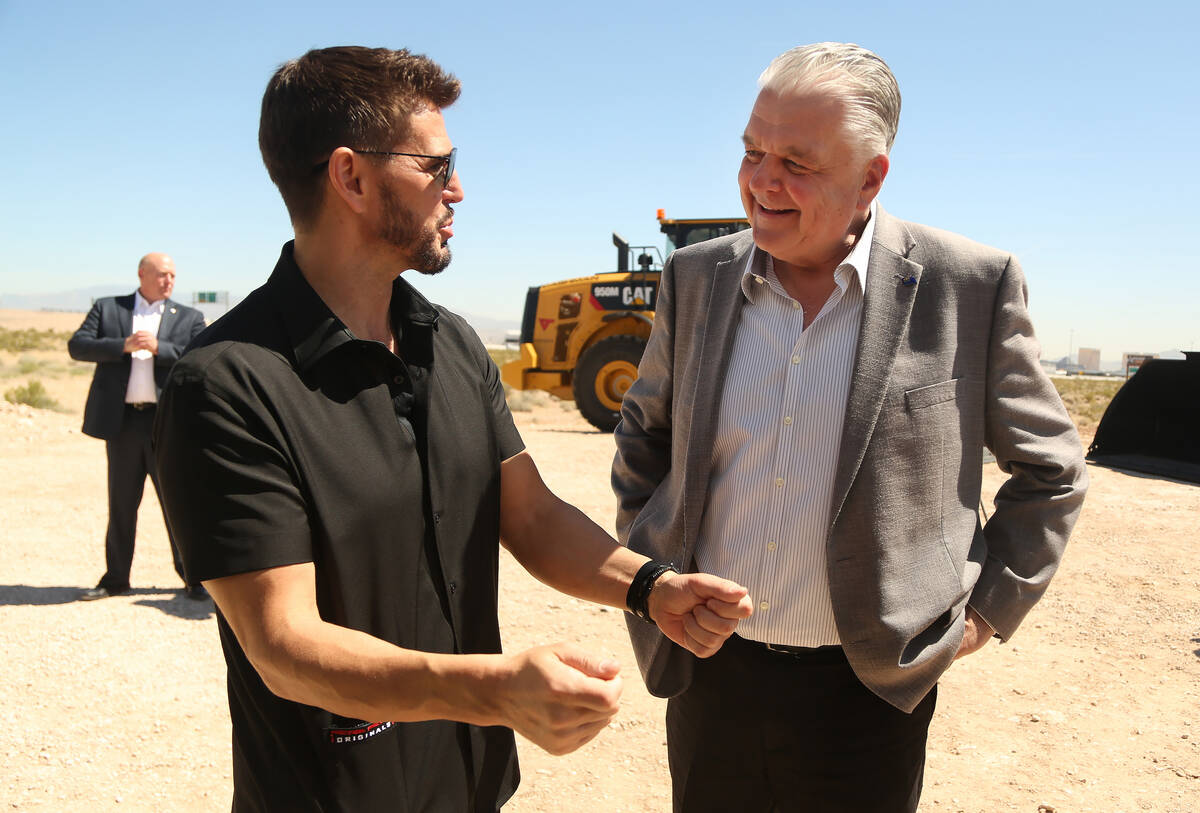 CEO of Switch Rob Roy, left, talks with former Nevada Governor Steve Sisolak, right, during a 2 ...