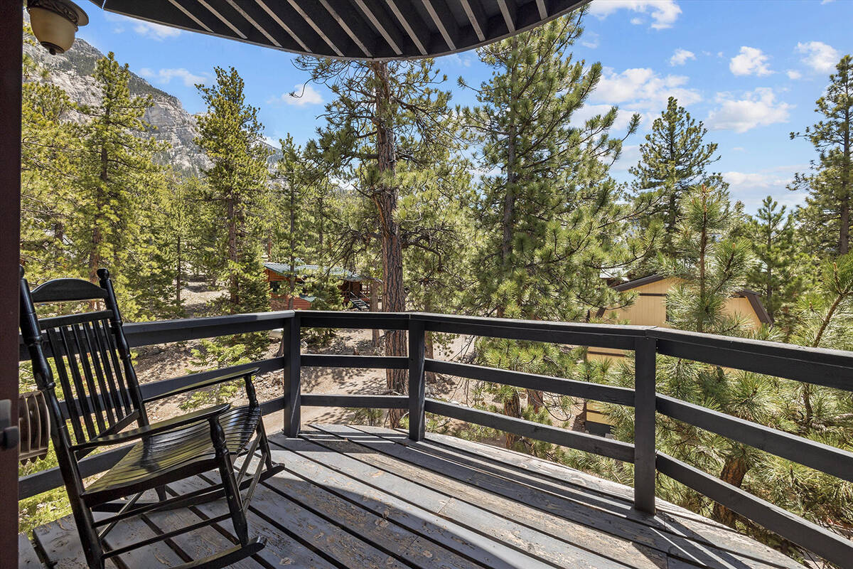 The cabin’s multiple decks capture panoramic views of the surrounding pine forest backdrop. ( ...