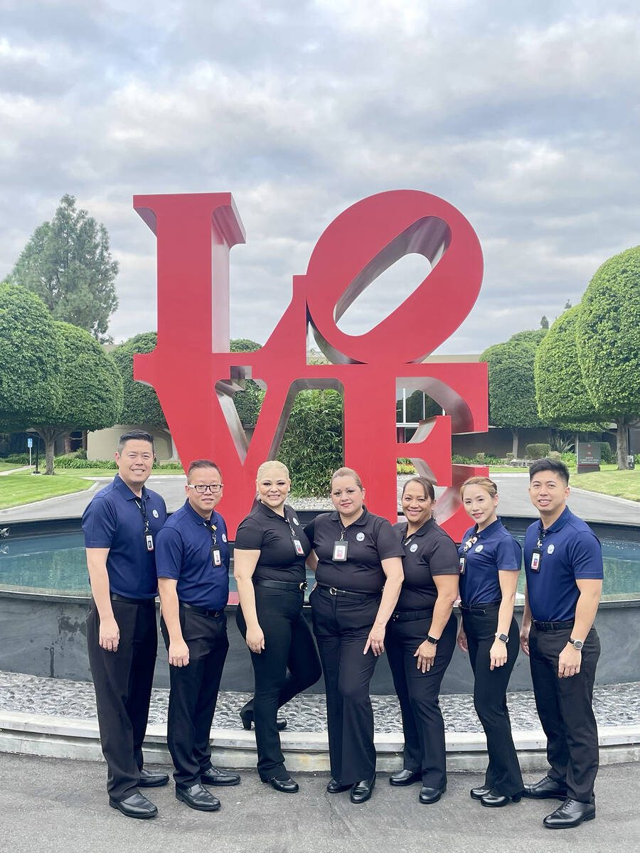 Panda Restaurant Group staffers pose for a photo by the LOVE statue at the 2023 Panda Leaders C ...