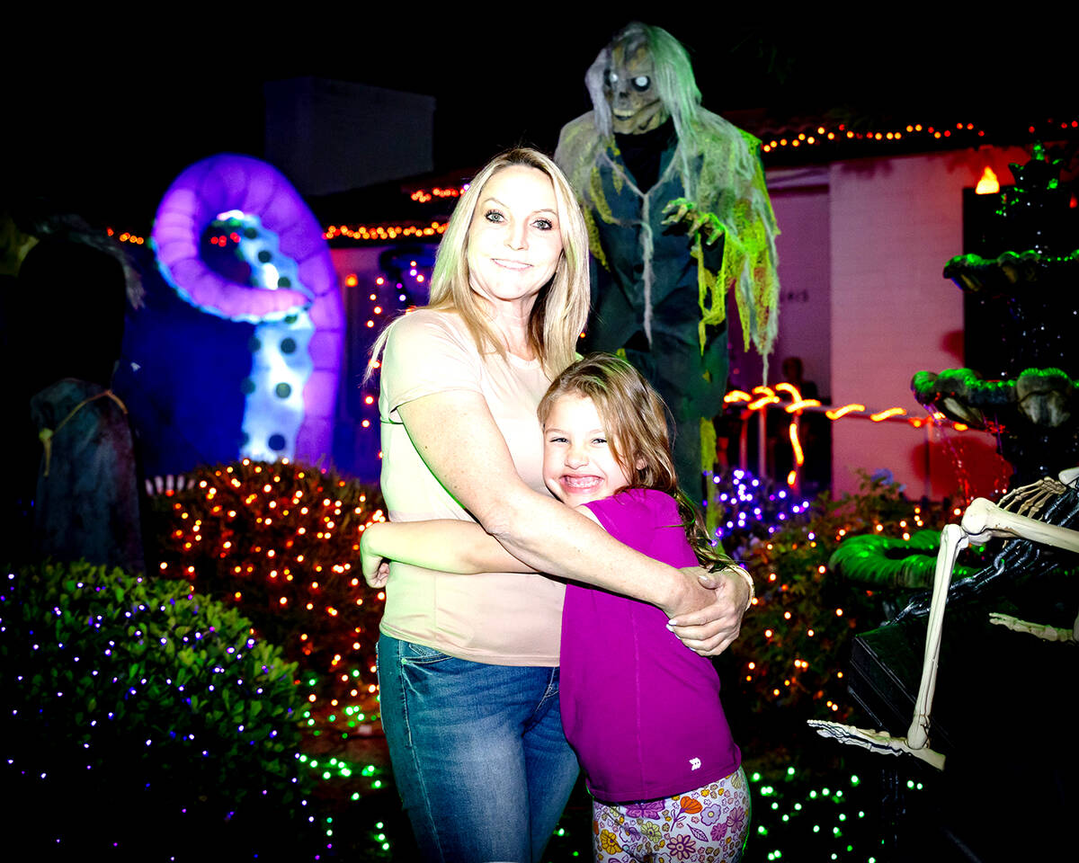 Destry Labo and daughter, Laila, stand in front of the "Halloween House," which features hundre ...