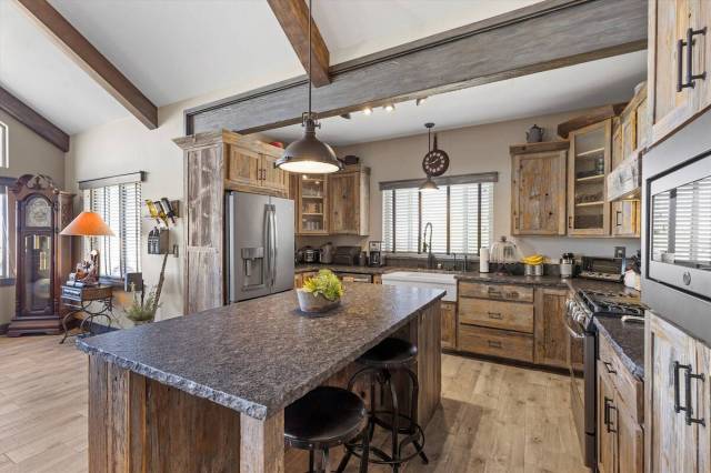 The kitchen showcases a central island with casual seating and modern conveniences such as a pr ...