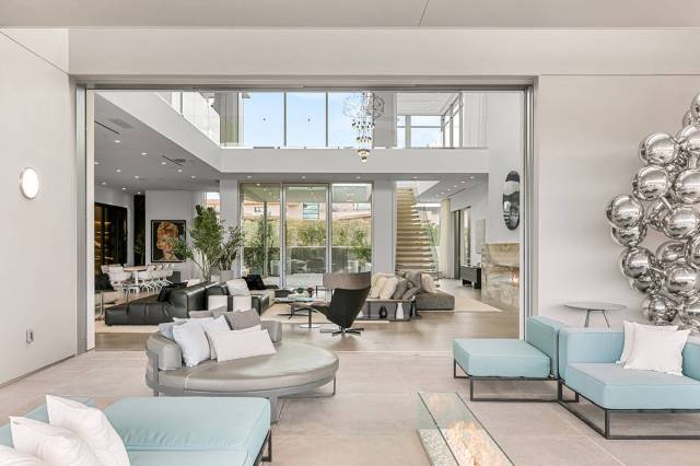 The great room features 24-foot ceiling and an array of floor-to-ceiling windows, adorned with ...