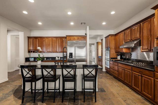 The kitchen has an island with seating. (Fraser Almeida, Luxury Homes Photography)
