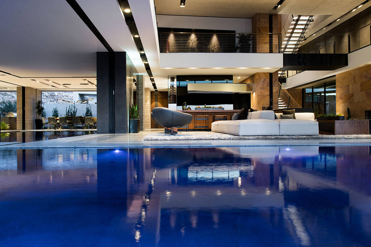 Surrounded by water on three sides, the main-level great room’s design combines polished conc ...