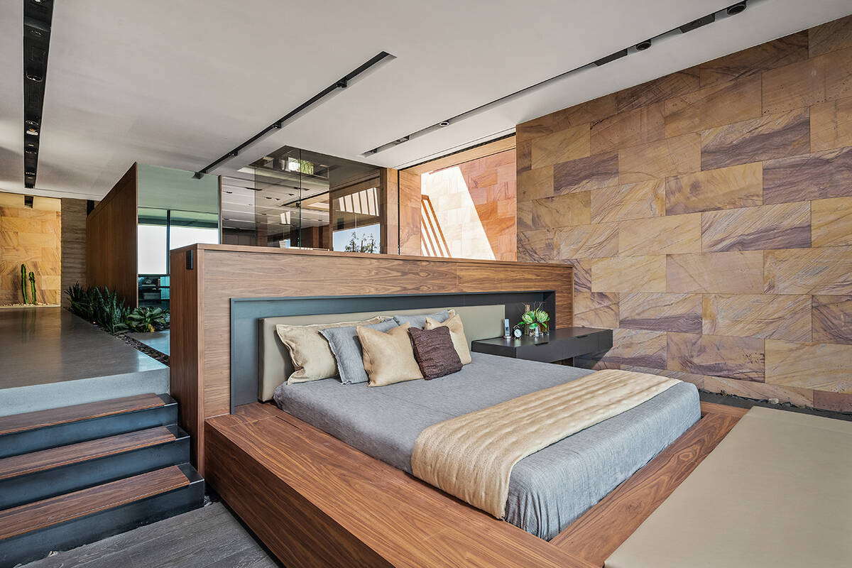 The private master retreat features metaquartzite stone walls, a beverage bar and expansive wal ...