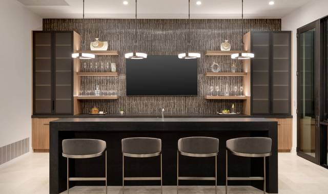 The Summit home's kitchen has all the top-tier appliances, such as double ovens, built-in espre ...