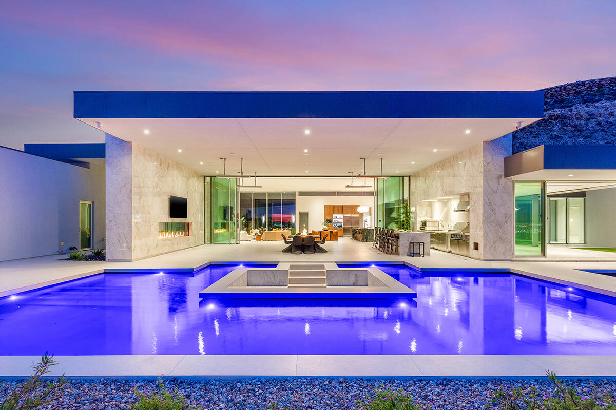 The resort-style backyard of this Ascaya mansion includes a pool and spa, a sunken fire lounge ...